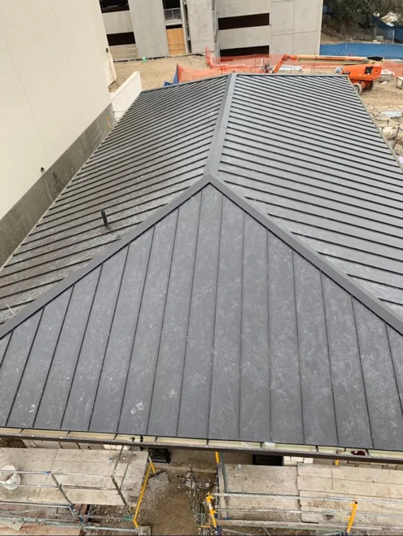 Commercial metal roof construction with crane equipment in Vincent